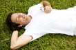 Man lying on the grass listening to personal stereo