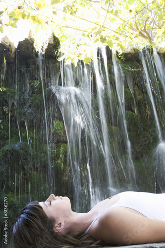 Photo: A woman relaxing by a waterfall A woman relaxing by a waterfall