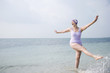 Senior woman in a swimsuit and swimming hat, at the beach