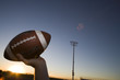 Photo: American football quarterback about to throw ball during competitive game on pitch at sunset, close-up, profile (lens flare) American football quarterback about to throw ball during competitive game on pitch at sunset, close-up, profile (lens flare)