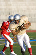 Photo: American football player chasing opposing player running with ball during competitive game American football player chasing opposing player running with ball during competitive game