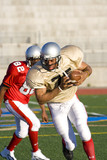 Photo: American football player chasing opposing player running with ball during competitive game American football player chasing opposing player running with ball during competitive game