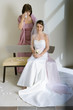 Photo: Bride in wedding dress sitting on bench, mother standing behind, wiping away tears of joy with handkerchief, smiling, portrait Bride in wedding dress sitting on bench, mother standing behind, wiping away tears of joy with handkerchief, smiling, portrait