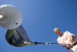 Photo: Mature man preparing to tee off on golf course, holding driver, close-up, upward view (wide angle) Mature man preparing to tee off on golf course, holding driver, close-up, upward view (wide angle)