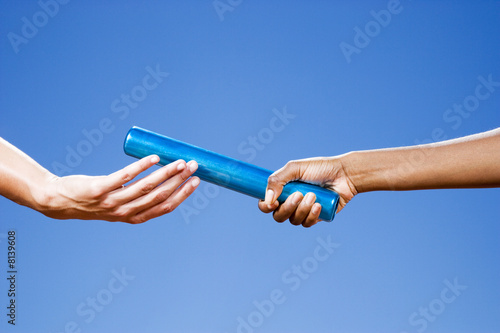 Foto: Baton passing between relay runners Baton passing between relay runners