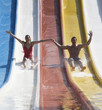 A couple coming down a slide in a waterpark