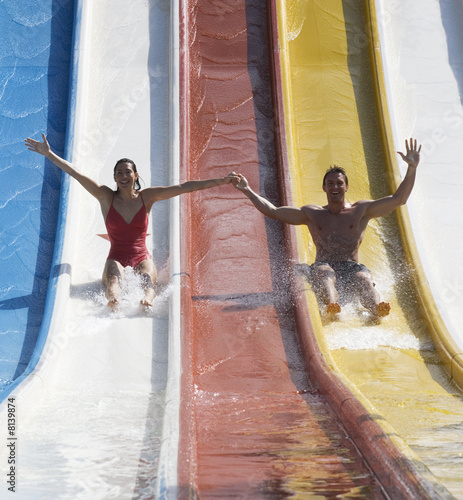 Photo: A couple coming down a slide in a waterpark A couple coming down a slide in a waterpark