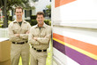Removal men standing beside their van with packing boxes