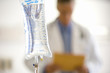 IV bag, male doctor in background (differential focus)