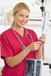 Young female nurse adjusting IV stand, smiling, portrait