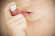 Female asthma sufferer using an inhaler