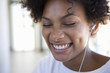 Young woman wearing earphones, smiling, close-up