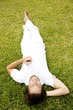 Man lying on the grass listening to personal stereo