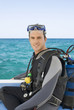 A man sitting on a boat about to go scuba diving