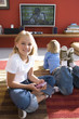 Photo: Boy and girl (6-8) on rug in front of television, portrait of girl smiling and using mp3 player Boy and girl (6-8) on rug in front of television, portrait of girl smiling and using mp3 player