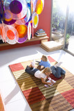 Photo: Boy and girl (6-8) on rug in front of television, girl with book and mp3 player, elevated view Boy and girl (6-8) on rug in front of television, girl with book and mp3 player, elevated view