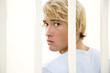 Portrait of a young man behind bars