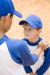 older boy talking down to younger boy at baseball practice