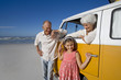 Photo: Senior couple on beach, woman in camper van holding hand of granddaughter (7-9), smiling, portrait Senior couple on beach, woman in camper van holding hand of granddaughter (7-9), smiling, portrait