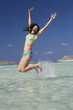 A woman jumping in the sea