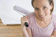 Young woman with paint roller, smiling, portrait, elevated view