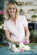Woman florist creating a bouquet of pink and white roses