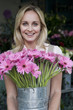 Woman florist or gardener holding a large pot of pink asters