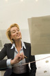 Photo: Businesswoman preparing to sign paperwork on glass table, smiling, low angle view through glass Businesswoman preparing to sign paperwork on glass table, smiling, low angle view through glass