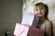 Little girl holding a stack of presents