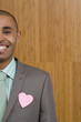 Photo: Businessman wearing heart shaped decoration on jacket, smiling, portrait (section) Businessman wearing heart shaped decoration on jacket, smiling, portrait (section)