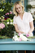 Woman florist creating a bouquet of pink and white roses