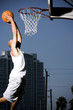Foto: Young African American man jumping with a basketball on an urban basketball court Young African American man jumping with a basketball on an urban basketball court