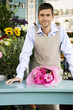 Male florist with bouquet of flowers at the shop counter