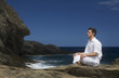 A man meditating by the sea