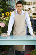 Male florist standing behind the counter in his shop