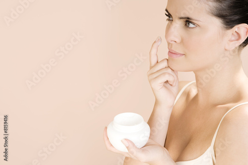 Photo: Woman applying moisturising cream to her face Woman applying moisturising cream to her face