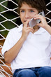 little boy talking on cell phone sitting in hammock