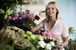 Woman florist in her shop, surrounded by an assortment of flowers
