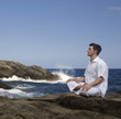 A man meditating by the sea