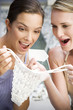 Two women sitting outside laughing at sexy underwear they've just purchased