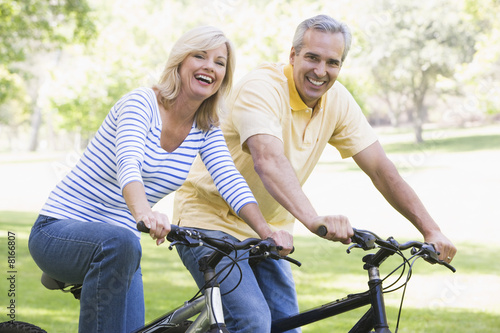Couple on bikes outdoors smiling