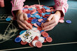 Man collecting pile of gambling chips on table, close-up