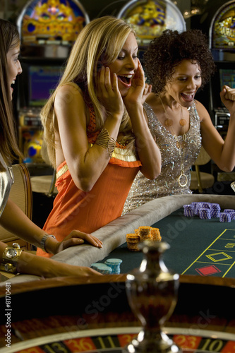 Photo: Young women gambling at roulette table, smiling in celebration Young women gambling at roulette table, smiling in celebration