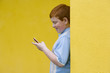 Boy (9-11) with mobile phone, smiling, side view