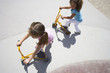 Girls (4-6) playing on tricycle scooters, elevated view