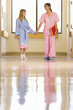 Nurse holding girl's hand in hospital hallway, low angle view