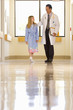 Doctor with girl in hospital hallway, low angle view