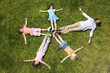 Woman with girls (4-8) lying on grass making star shape