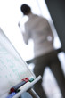 Man by whiteboard, rear view
