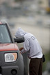 Man in hood unlocking car door